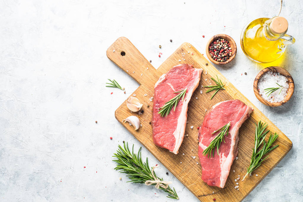Raw beef striploin steak on cutting board.  - Photo, Image