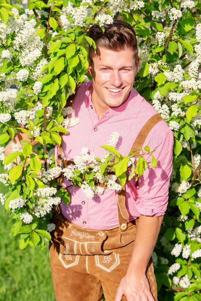 handsome bavarian blond man standing outdoors - 写真・画像