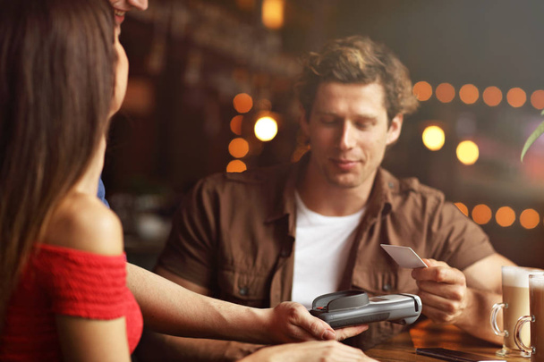 Cute para na randkę w kawiarni, płacąc kartą kredytową - Zdjęcie, obraz