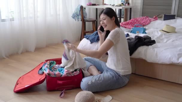 The woman just came back from the foreign country and she is cleaning up her clothes. She clssify them into different pile. - Video