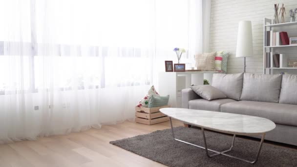 Moderní obývací pokoj v jednoduchý životní styl. Existují rohože, gauč, lampy, stolní, polštáře, krabice a police v tomto obývacím pokoji čisté a světlé. - Záběry, video