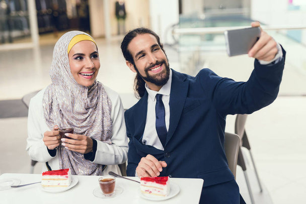 Arab woman and man taking selfie after shopping - Foto, afbeelding