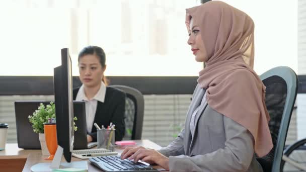 successful confidence Muslim businesswoman working in the modern office and cross hand arm face to the camera while her coworker working in the background. - Video