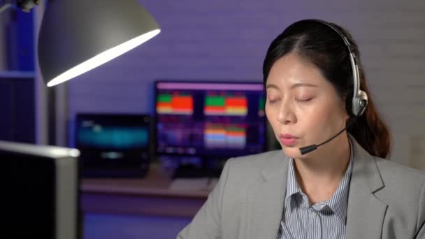 Ritratto di asia sorridente operatore telefonico di assistenza clienti femminile sul posto di lavoro che lavora a tarda notte. concetto di servizio 24 ore su 24
 - Filmati, video