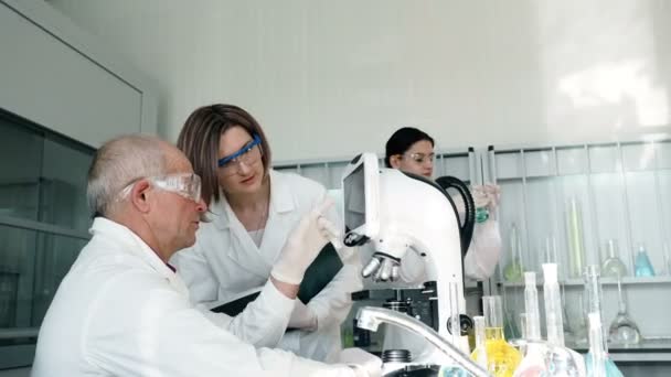Les gens travaillent en laboratoire clinique avec microscope
 - Séquence, vidéo