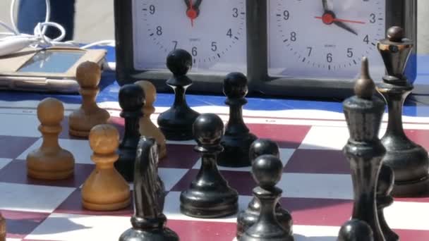 21 de abril de 2018 - Kamenskoye, Ucrânia: Crianças jogam xadrez na rua. Torneio de xadrez de rua ao ar livre, relógio de xadrez pressiona a mão
 - Filmagem, Vídeo