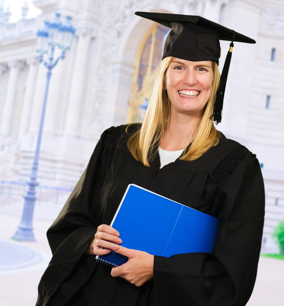 Feliz graduada mujer sosteniendo un cuaderno
 - Foto, imagen