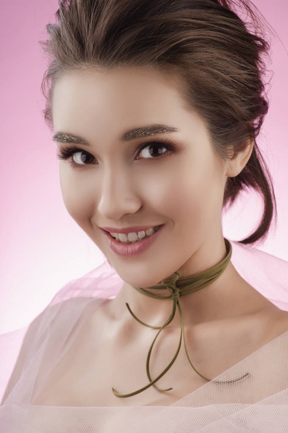 Closeup portrait of a beautiful smiling asian girl wearing pink  - 写真・画像