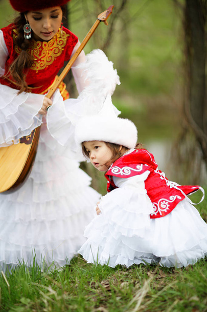 カザフ民族衣装の人々。女性と公園で娘 - 写真・画像