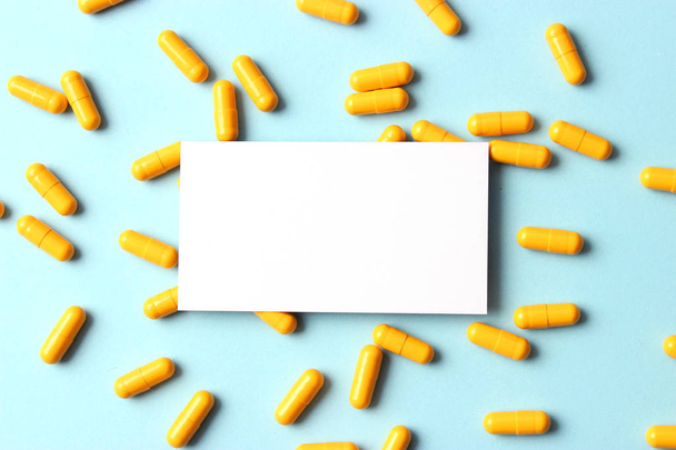 pílulas bonitas amarelas em um fundo azul com espaço para texto. minimalismo. criativo
. - Foto, Imagem