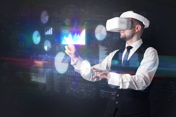 Man wearing VR goggles with charts and reports - 写真・画像