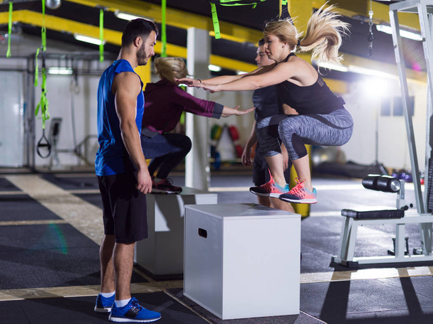 athletes working out  jumping on fit box - Fotó, kép