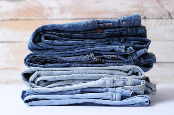 Una pila perfetta di jeans di diversi colori su uno sfondo chiaro. minimalismo, design
, - Foto, immagini