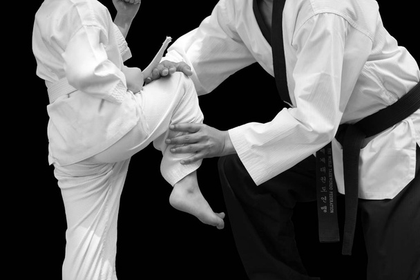 Człowiek nauczania Taekwondo Fighter dziecko równowagi stać na lot na czarnym tle - Zdjęcie, obraz