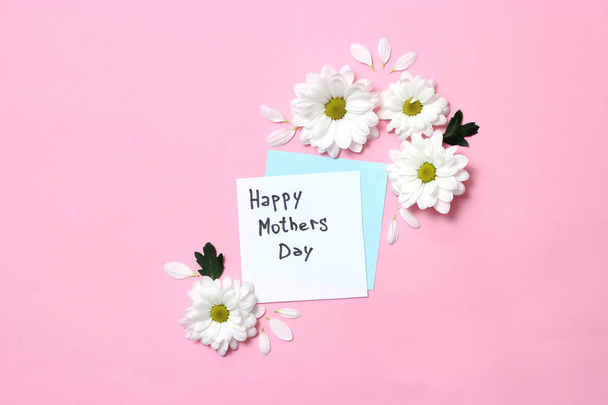 schöne Komposition von Blumen zum Tag der Mutter. Postkarte "Happy Mother 's Day" auf pastellfarbenem Hintergrund mit Blumen. Glückwunsch. Minimalismus, Draufsicht. flache Lage  - Foto, Bild