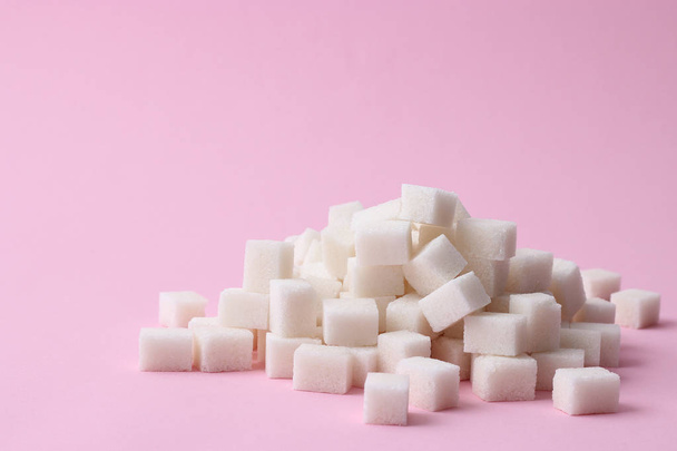 A handful of sugar cubes on a pastel background. the sugar pyramid. minimalism, design, diabetes, sweets, calories.  - Foto, Bild