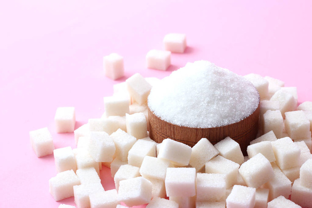 Kourallinen sokeria pastellitaustalla, jossa on paikka tekstin liittämiseksi. sokeripalat ja löysä. minimalismi, alkuun
 - Valokuva, kuva