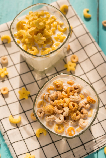 arriba ver dos tazas de leche con anillos de cereales en una mañana soleada como desayuno saludable
 - Foto, Imagen