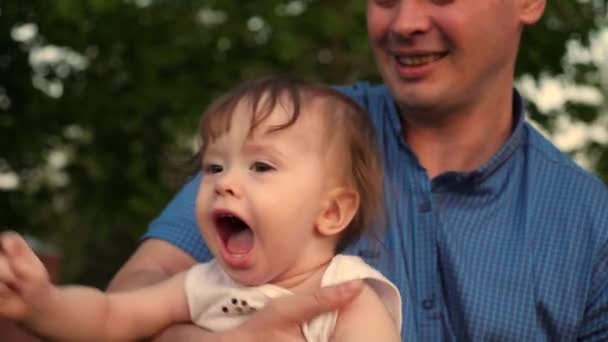 Bebé se ríe cuando su hermoso padre joven lo bombea a través del aire
. - Metraje, vídeo