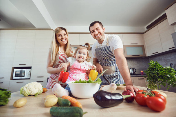 A happy family prepares food  in the kitchen. - 写真・画像