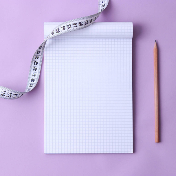 open notepad, pencil and centimeter tape on a pastel background with space for text. concept of health, healthy diet, diet, weight loss. minimalism. flatlay  - Foto, afbeelding