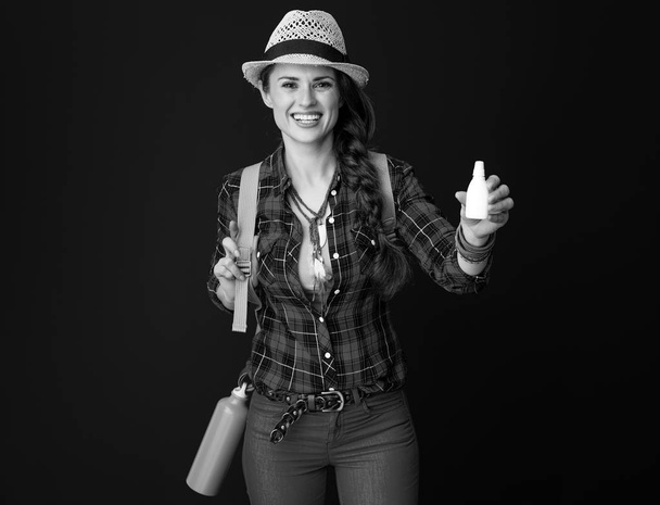 happy fit traveler woman in a plaid shirt showing nasal drops - Foto, Imagen