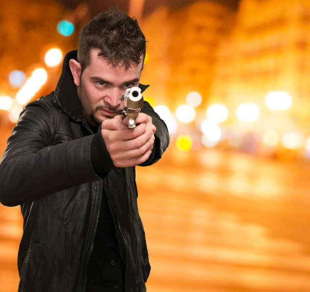 jeune homme pointant avec un pistolet
 - Photo, image