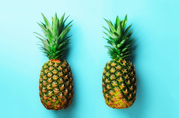 Fresh pineapples on blue background. Top View. Pop art design, creative concept. Copy Space. Bright pineapple pattern for minimal style. - Foto, Imagen