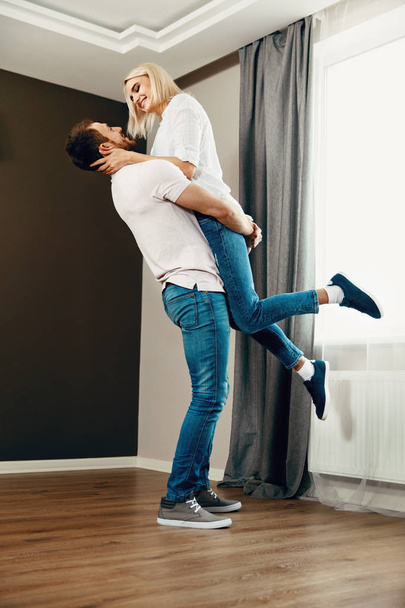 Moving Day. Man Hugging Woman In New Home - Foto, Bild