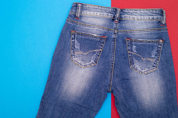 Обветшалые джинсы голубого цвета на цветном фоне
 - Фото, изображение