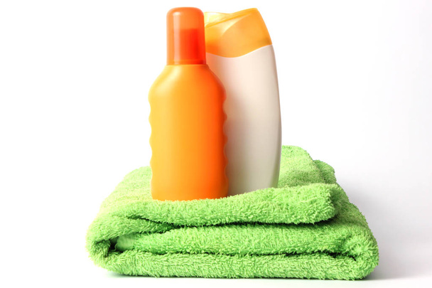 солнцезащитный крем и полотенце изолированы на белом
. - Фото, изображение