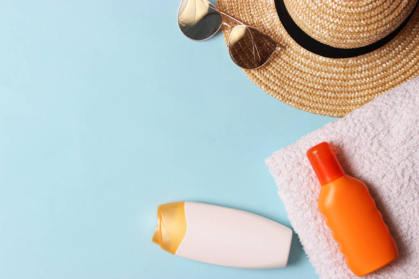 sunscreen, towel, hat, glasses on a colored background. Cosmetics for safe sunburn.top view, flatlay  - Foto, immagini