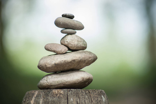 stones balance on wooden fence on green blurred background - Fotografie, Obrázek