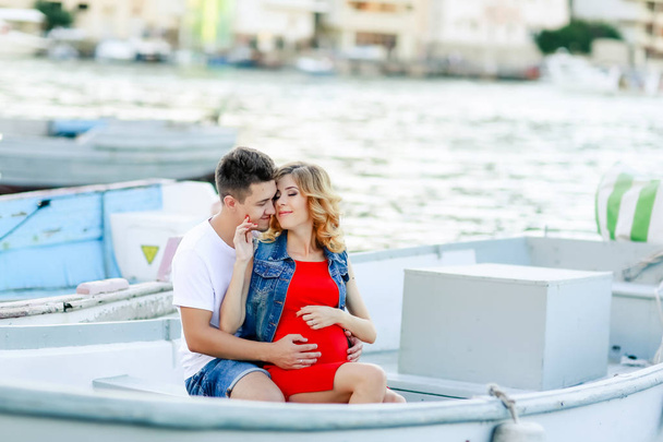 pregnant wife with husband posing outdoors on the pier  - Foto, Imagem