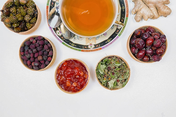 τσάι για την υγεία, τσάι τζίντζερ, λινάρι, γρασίδι, φράουλες, κώνους, hawthorn, canina-ροζ - Φωτογραφία, εικόνα