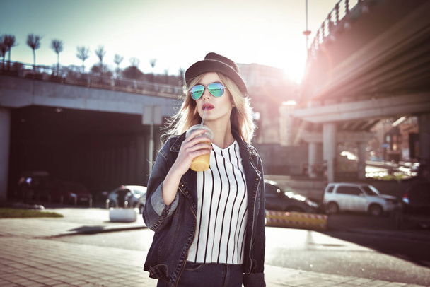 Söpö tyttö pitää mehua kaupungissa aurinkolasit hattu
 - Valokuva, kuva