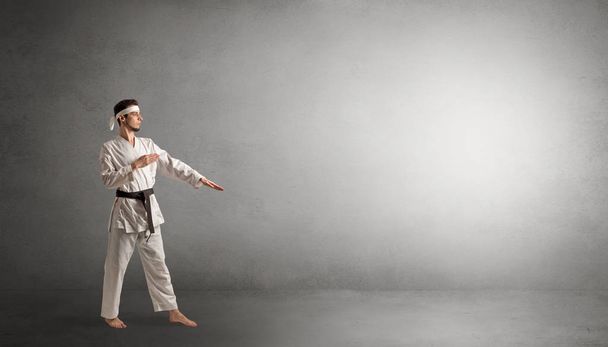Small karate man fighting in an empty space - Foto, imagen