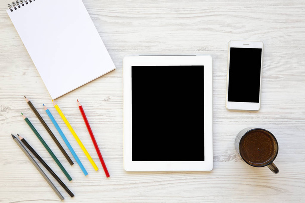 Espace de travail féminin avec tablette, smartphone, ordinateur portable, crayons de couleur et latte. Vue du dessus
. - Photo, image