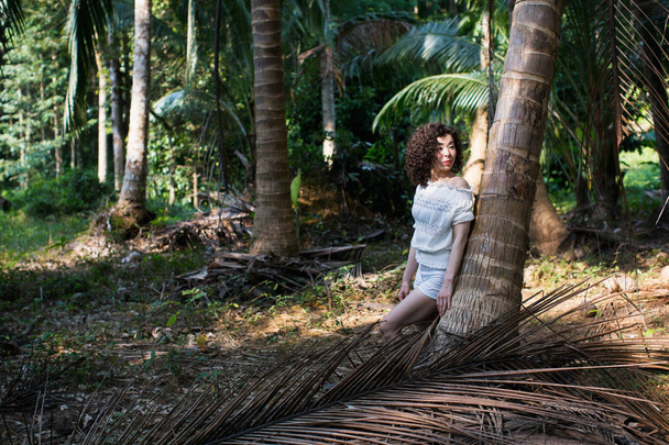 Pretty young woman of mixed race in the tropical forest - 写真・画像