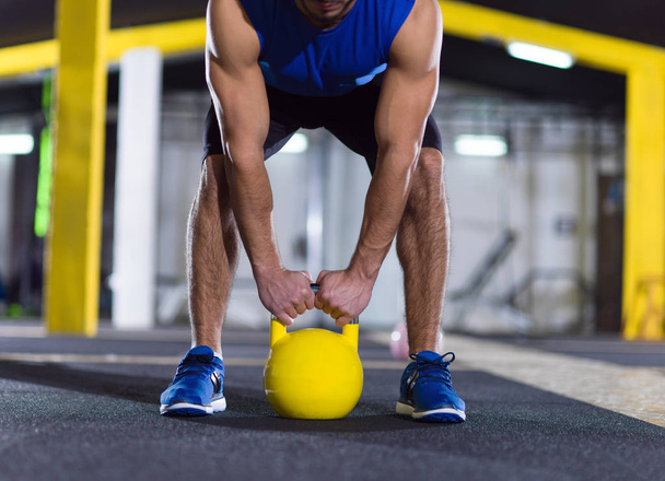young  man athlete exercise with fitness kettlebell at crossfitness gym - Foto, imagen