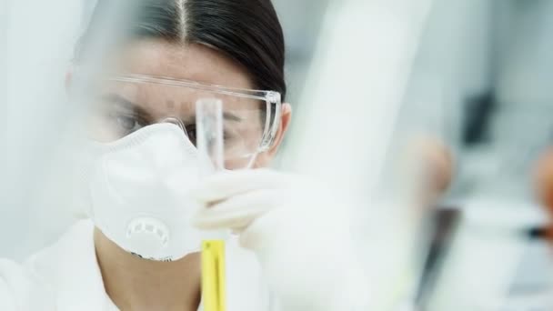Ženské výzkumník experimentovat s kapalinou v laboratoři - Záběry, video