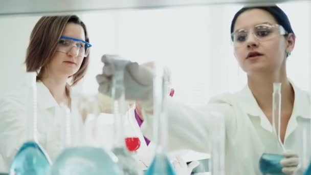 Two women work in laboratory with test tubes - Footage, Video