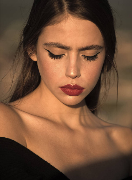 girl with red lips. Hairdresser and skincare, summer fashion. Beauty and fashion, cosmetics. Fashion look of stylish woman in black, makeup. Elegant woman with long hair. - 写真・画像