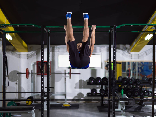 young muscular man doing pull ups on the horizontal bar as part of Crossfitness Training - Foto, Imagem