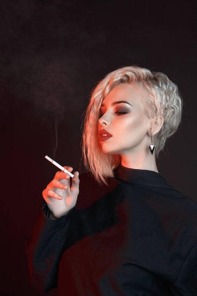 Young sexy woman smoking cigarette - 写真・画像