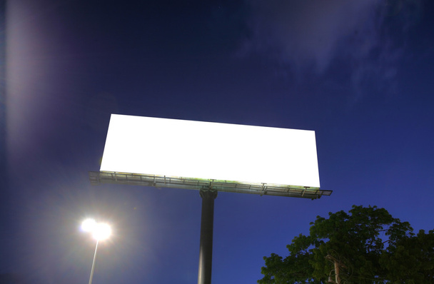 κενό billboard σε ένα μπλε ουρανό και πράσινο δέντρο φόντο - Φωτογραφία, εικόνα