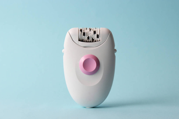 modern epilator on a colored background. minimalism. skin care, removal of unwanted hair. - Foto, imagen
