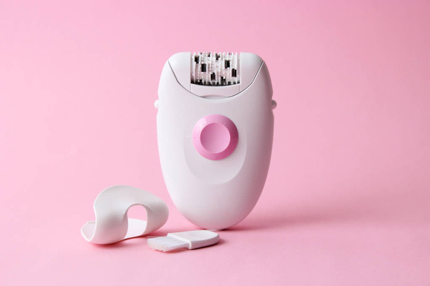 modern epilator on a colored background. minimalism. skin care, removal of unwanted hair. - Photo, Image