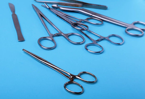 surgical instruments and tools including scalpels, forceps and tweezers arranged on a table for a surgery. - Fotó, kép