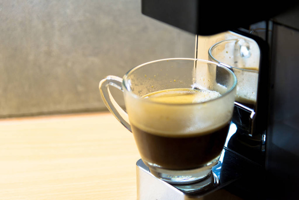 espresso machine with hot coffee in glass for refreshment - Photo, Image